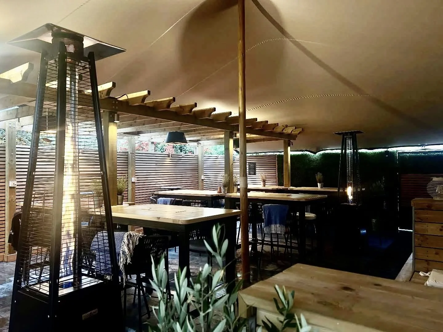 The Wildes garden under its canvas canopy, with wooden tables and warm lighting